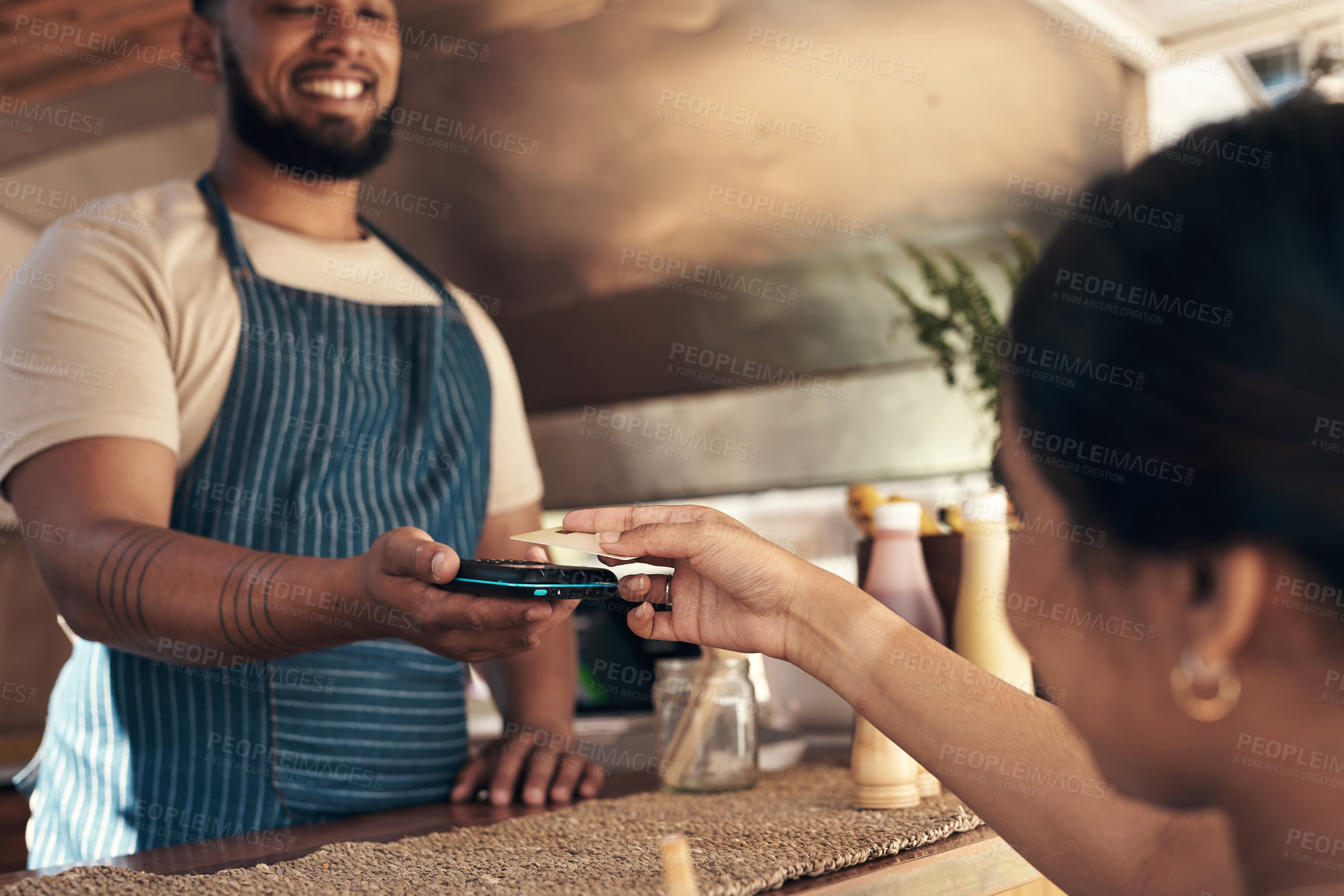 Buy stock photo Shot of a customer paying for their smoothie