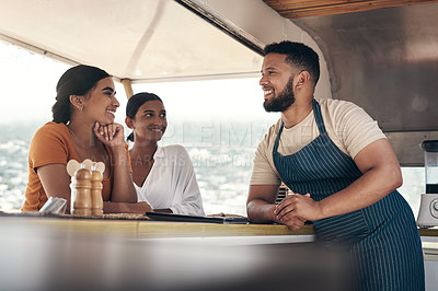 Buy stock photo Shot of two friends ordering food from a food truck