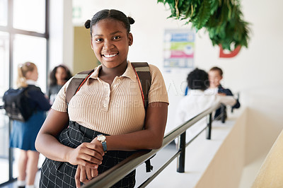 Buy stock photo Shot of a young girl standing in the hallway at school during the day