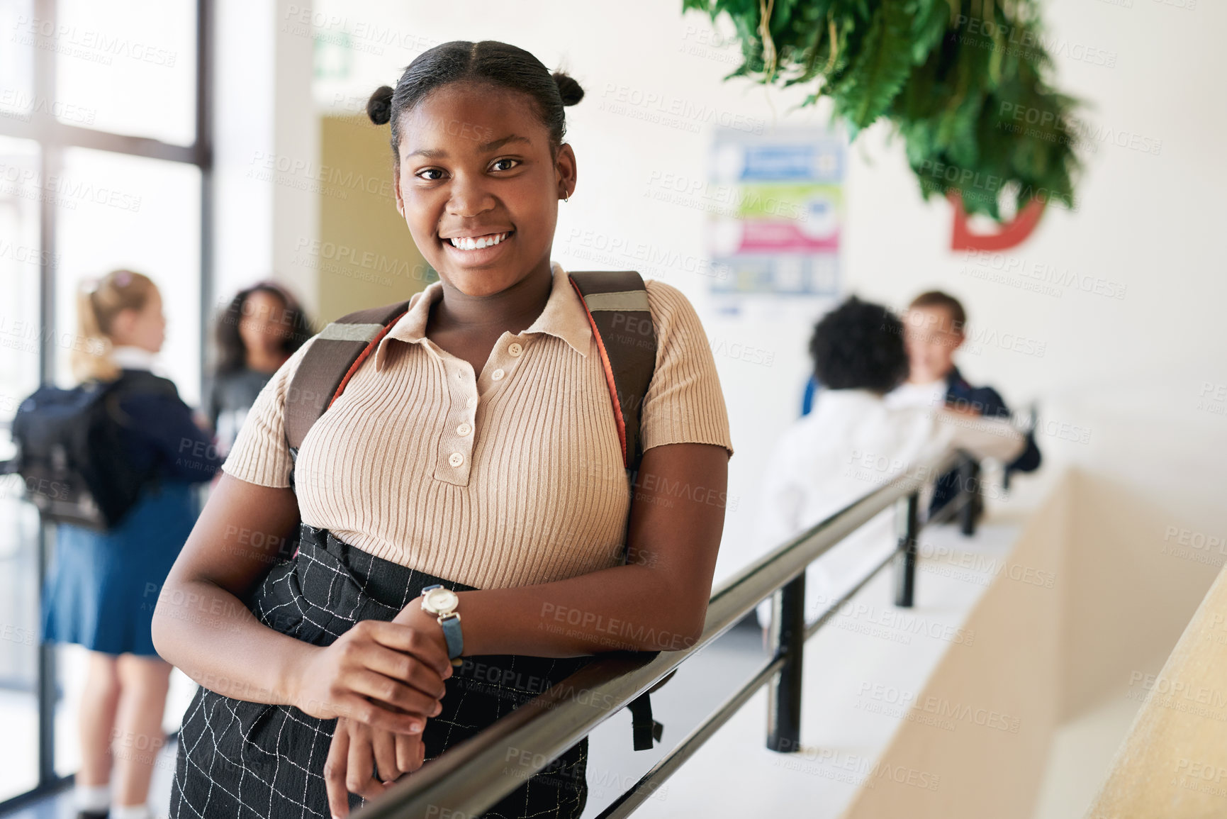 Buy stock photo Shot of a young girl standing in the hallway at school during the day