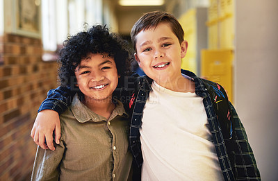 Buy stock photo Shot of two young boys standing in the hallway at school with their arms around each other