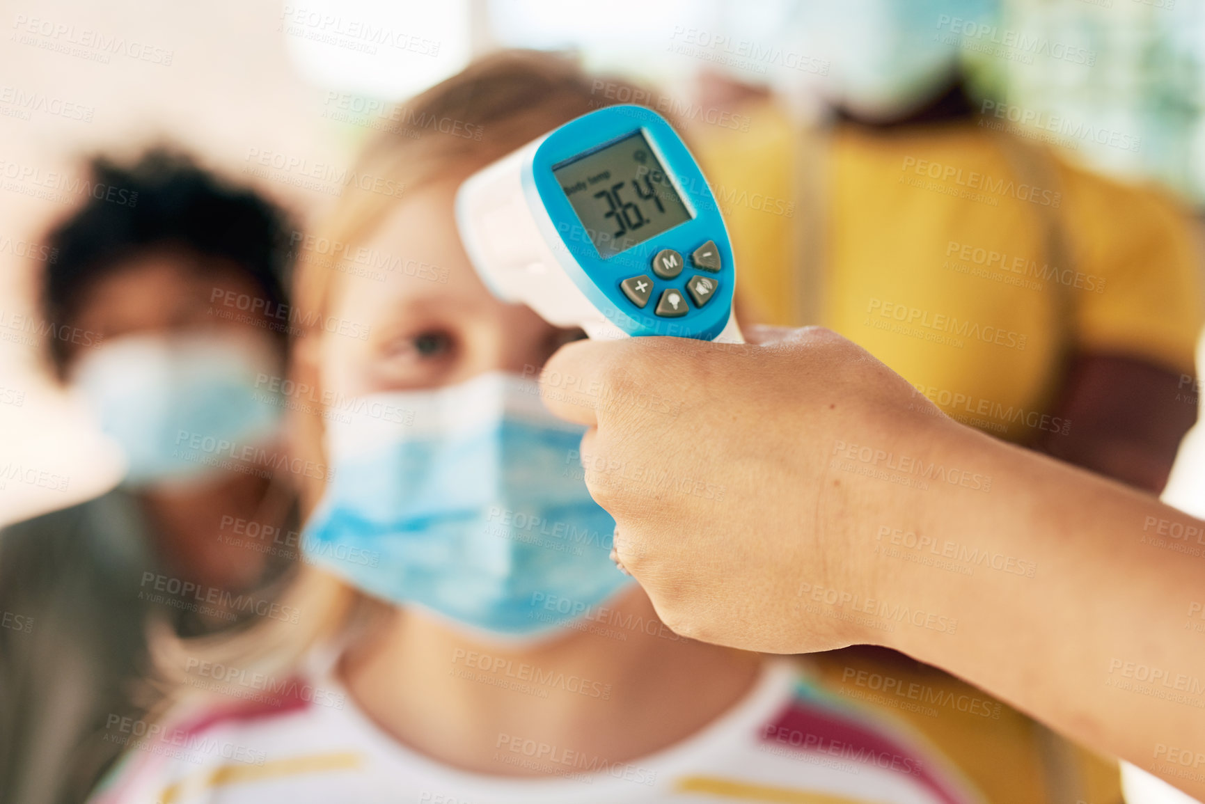 Buy stock photo Shot of an unrecognizable woman standing and using a thermometer to check her students' temperatures at school