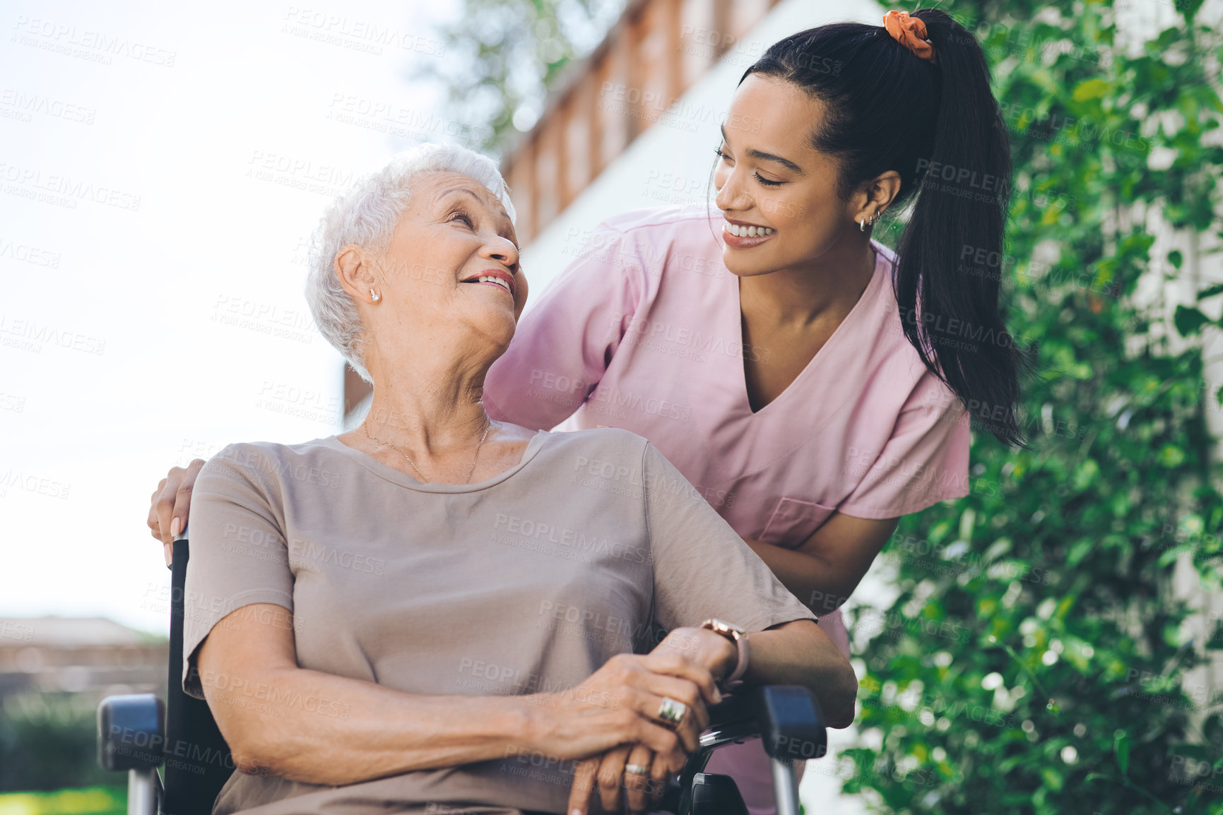 Buy stock photo Shot of a young nurse caring for an older woman in a wheelchair