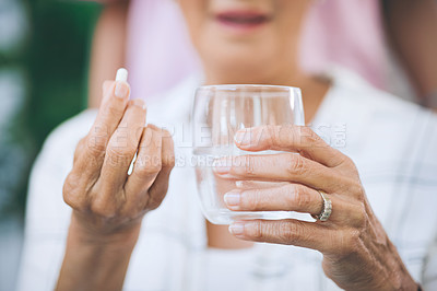 Buy stock photo Cropped shot of an unrecognizable woman taking medication