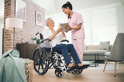 Buy stock photo Shot of a young nurse sharing information from her digital tablet with an older woman in a wheelchair