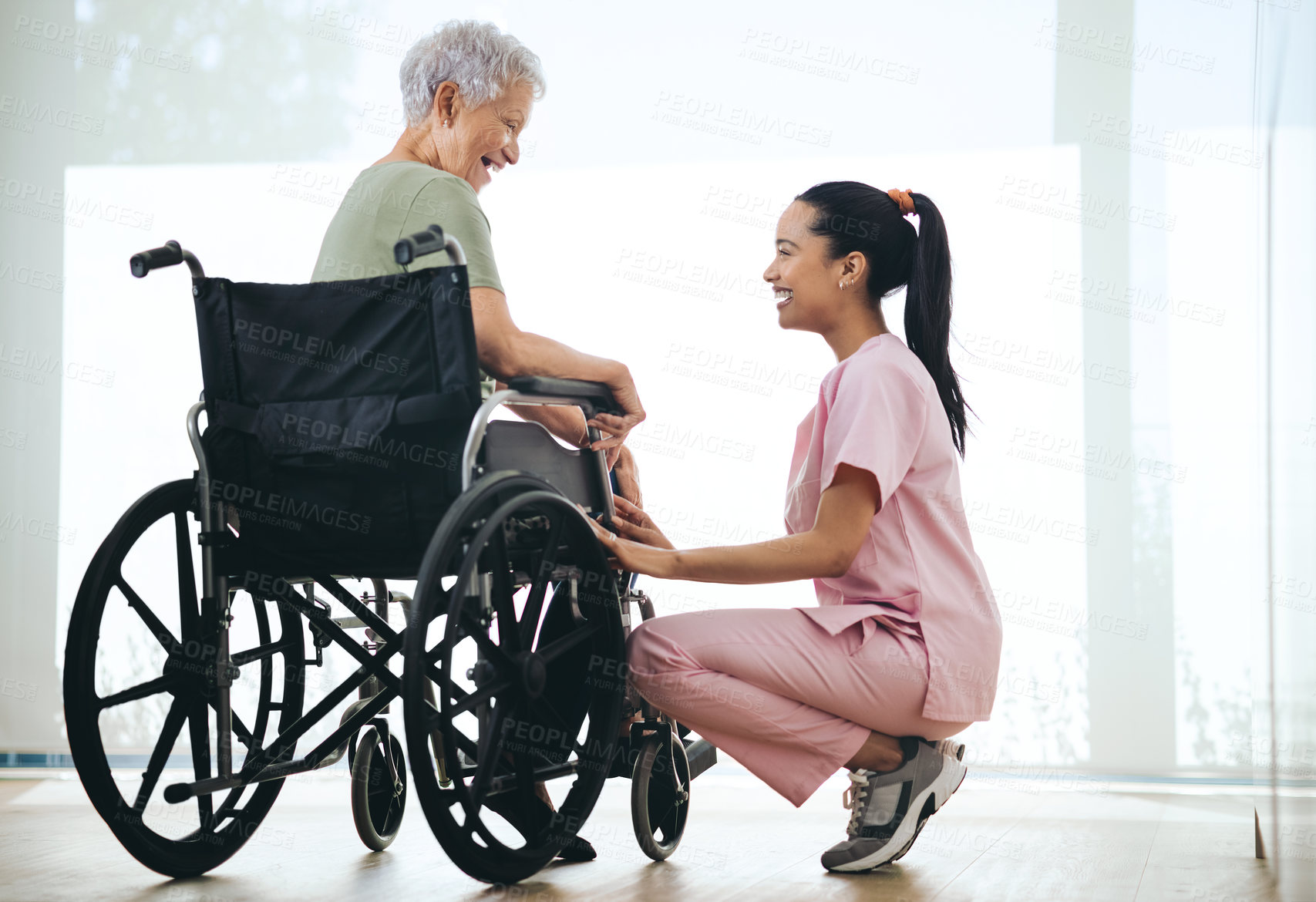 Buy stock photo Shot of a young nurse caring for an older woman in a wheelchair