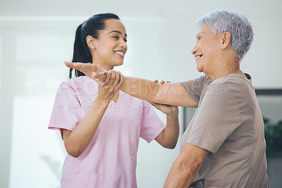 Buy stock photo Shot of an older woman doing light stretching exercises during a session with a physiotherapist inside