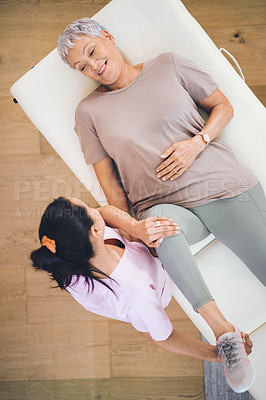 Buy stock photo Shot of an older woman doing light exercises during a session with a physiotherapist inside