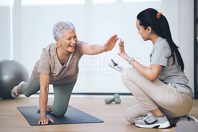 Buy stock photo Shot of an older woman doing light floor exercises during a session with a physiotherapist