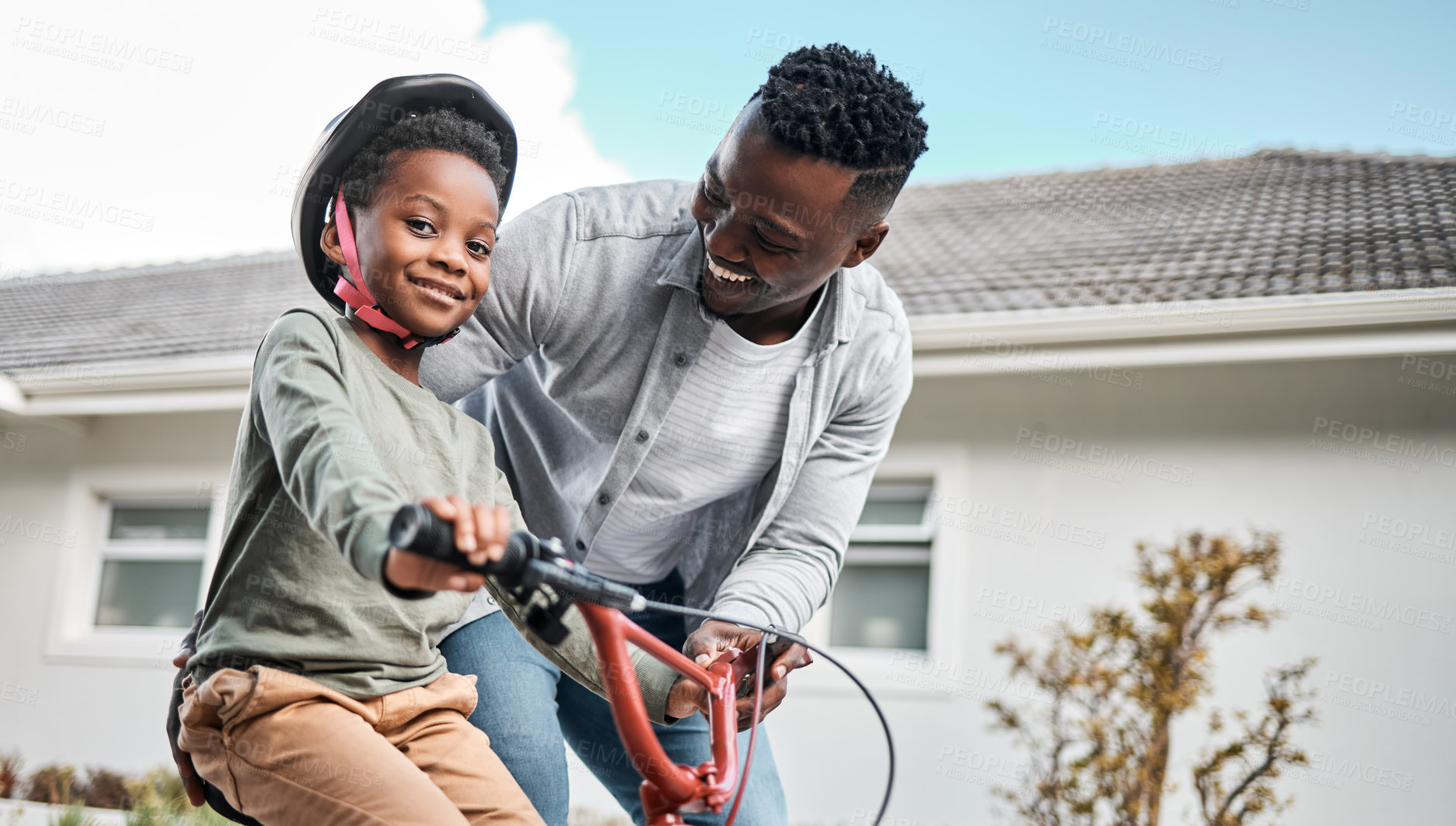 Buy stock photo Portrait of an adorable boy learning to ride a bicycle with his father outdoors