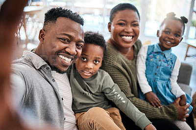 Buy stock photo Shot of a happy young family taking selfies on the sofa at home