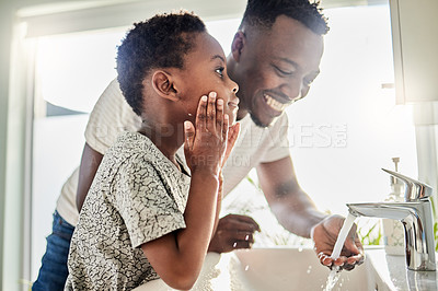 Buy stock photo Shot of a father and his son washing their faces together in a bathroom at home