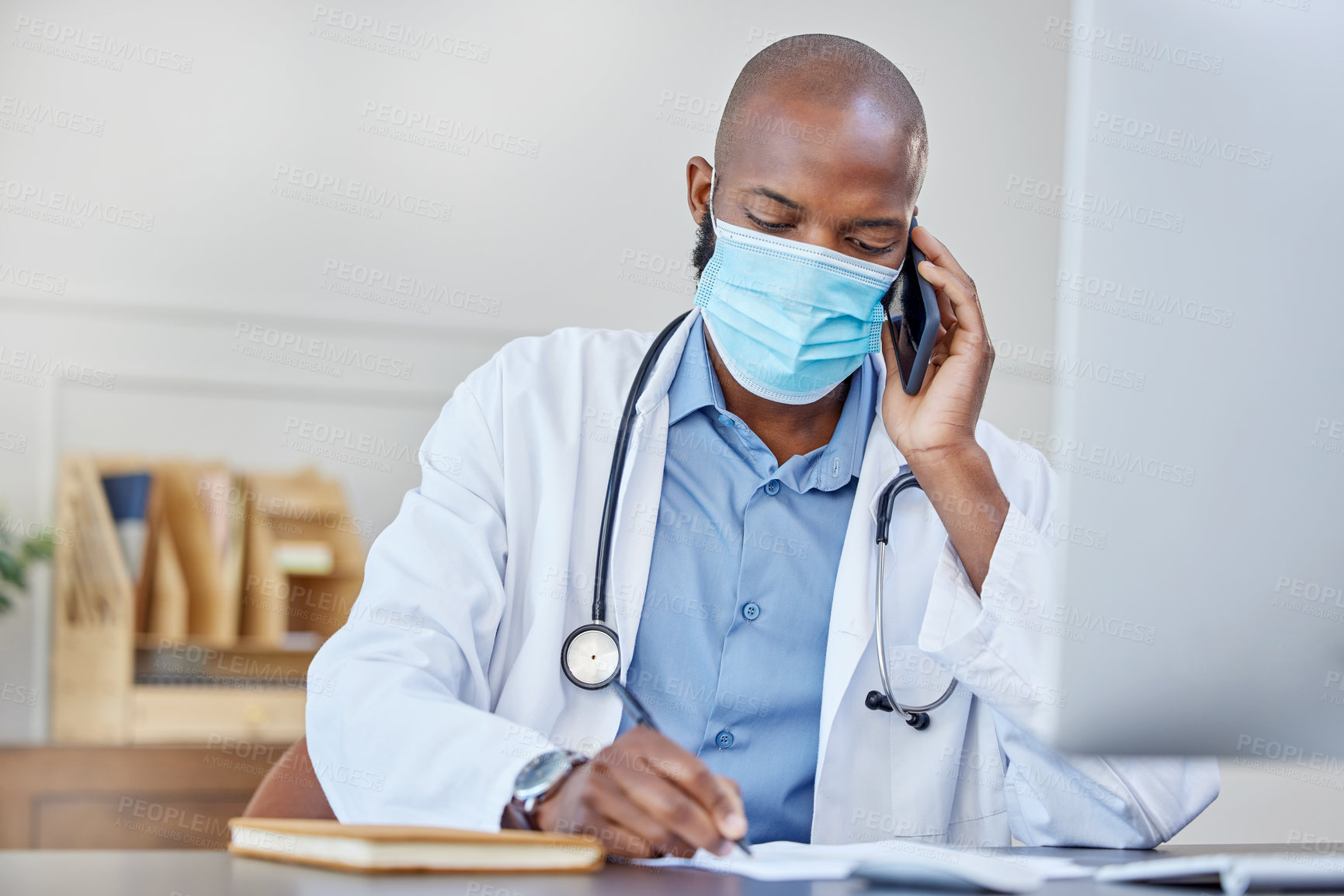 Buy stock photo Phone call, writing and doctor black man in mask at hospital for appointment or medical consulting. Computer, notebook and pen with healthcare professional at desk in office of clinic for checkup