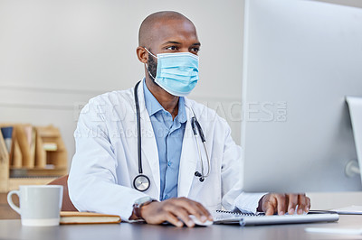 Buy stock photo Shot of a young doctor using a computer at work