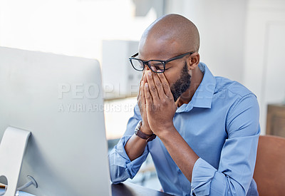 Buy stock photo Shot of a businessman looking stressed while sitting at his desk