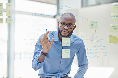 Buy stock photo Shot of a businessman brainstorming with sticky notes on a transparent board