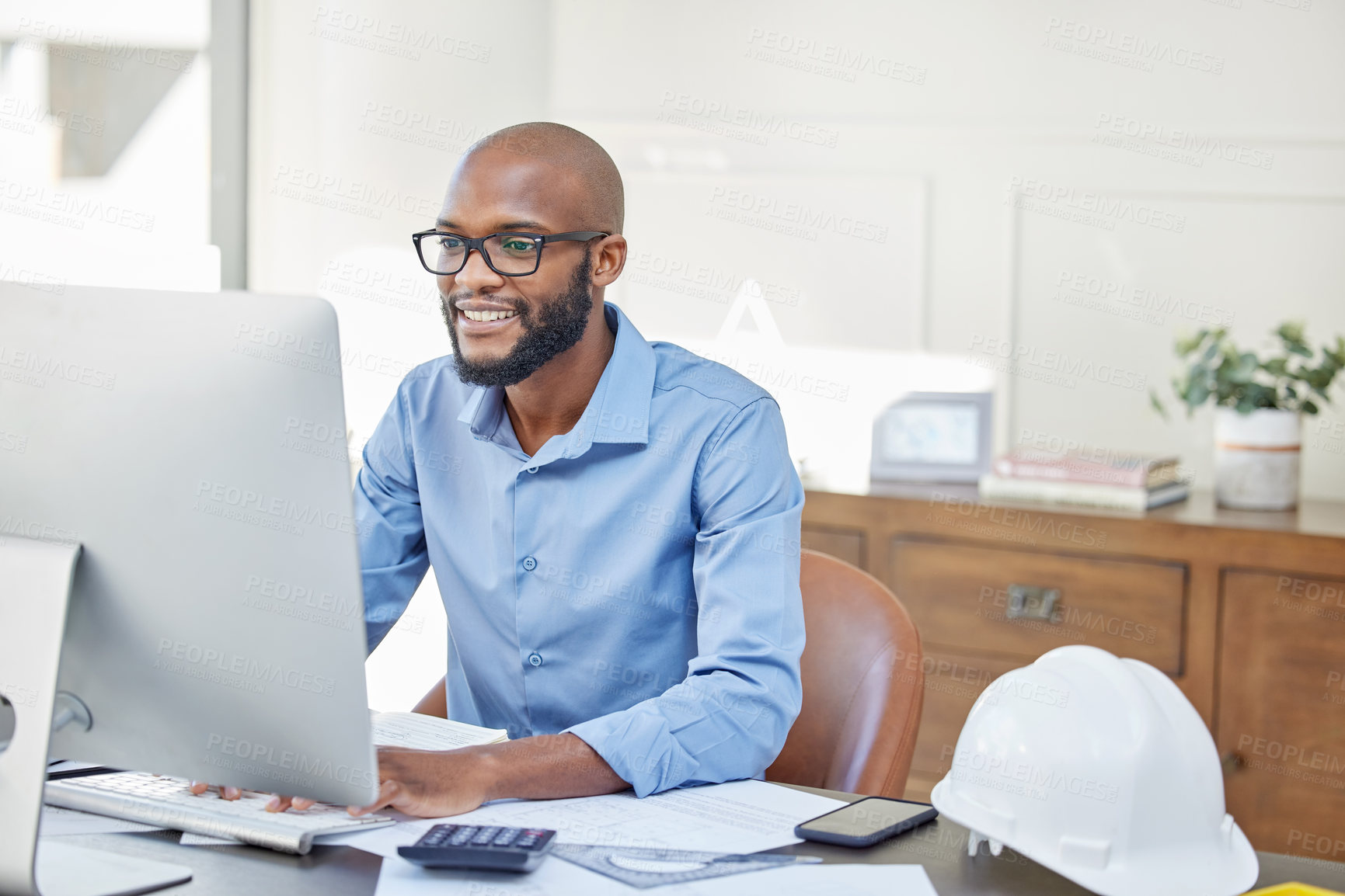 Buy stock photo Shot of a businessman using his computer while sitting at his desk