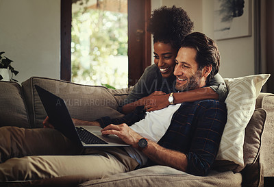Buy stock photo Laptop, subscription and an interracial couple watching a movie using an online streaming service for entertainment. Computer, relax or internet with a man and woman bonding together over a video