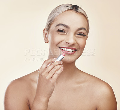 Buy stock photo Studio shot of a beautiful young woman applying pink lipstick