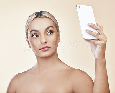 Buy stock photo Studio shot of a beautiful young woman taking a selfie