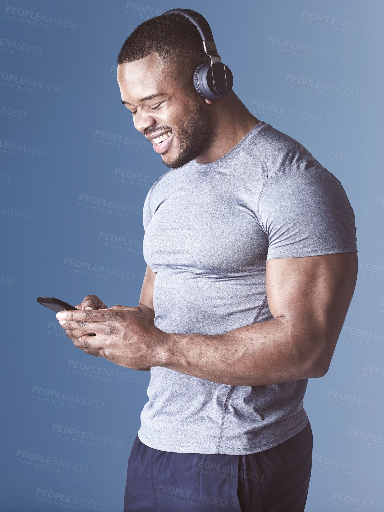 Buy stock photo Black man, headphones and music for fitness in studio, exercise and audio for workout motivation. Male person, phone and search playlist for online sound, training and athlete on blue background