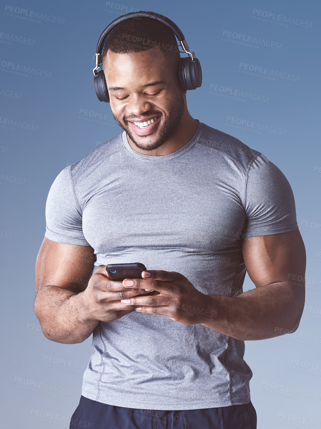 Buy stock photo Black man, music and phone for fitness in studio, exercise and audio for workout motivation. Male person, online and search playlist for sound or podcast, training and athlete on blue background