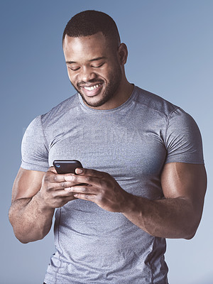 Buy stock photo Black man, phone and workout app in studio, training schedule and online for communication. Male person, athlete and internet for fitness website, typing and reading or scroll blog on blue background