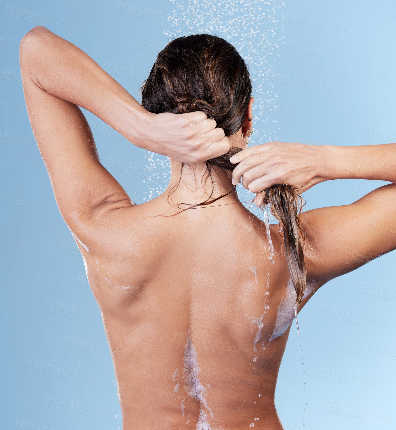 Buy stock photo Shower, back view and woman washing hair for shampoo, cosmetics and wellness cleaning or conditioner. Female person, happy and rinsing scalp in studio blue background for skin care or morning routine