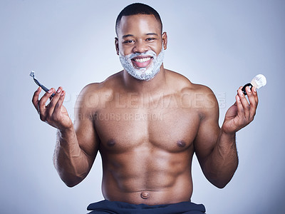 Buy stock photo Studio shot of a handsome young man with shaving foam on his beard against a blue background