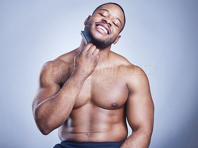 Buy stock photo Black man, beard brush and grooming in studio, confident and haircare on blue background. Male person, comb and maintenance for hygiene routine or cleaning, beauty and hair treatment for cosmetics