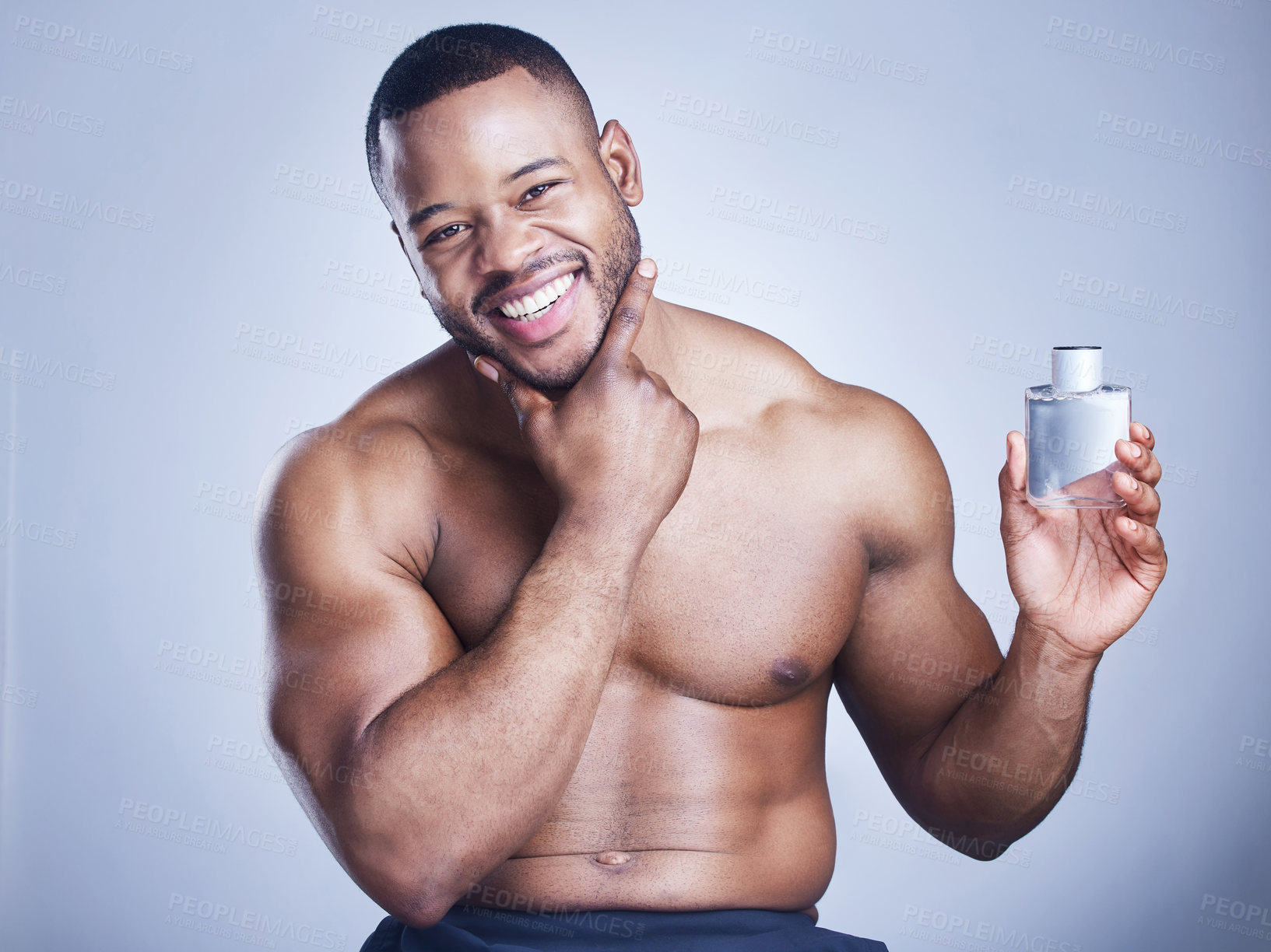 Buy stock photo Black man, cologne and bottle in studio portrait, body care and perfume spray on blue background. Person, deodorant and container for aroma or fresh scent, clean smell and shirtless for fragrance