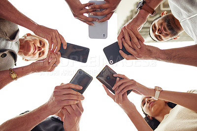 Buy stock photo Low angle shot of a group of unrecognisable people using their cellphones in synchronicity