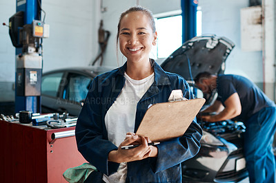 Buy stock photo Shot of a female mechanic holding a clipboard while working in an auto repair shop
