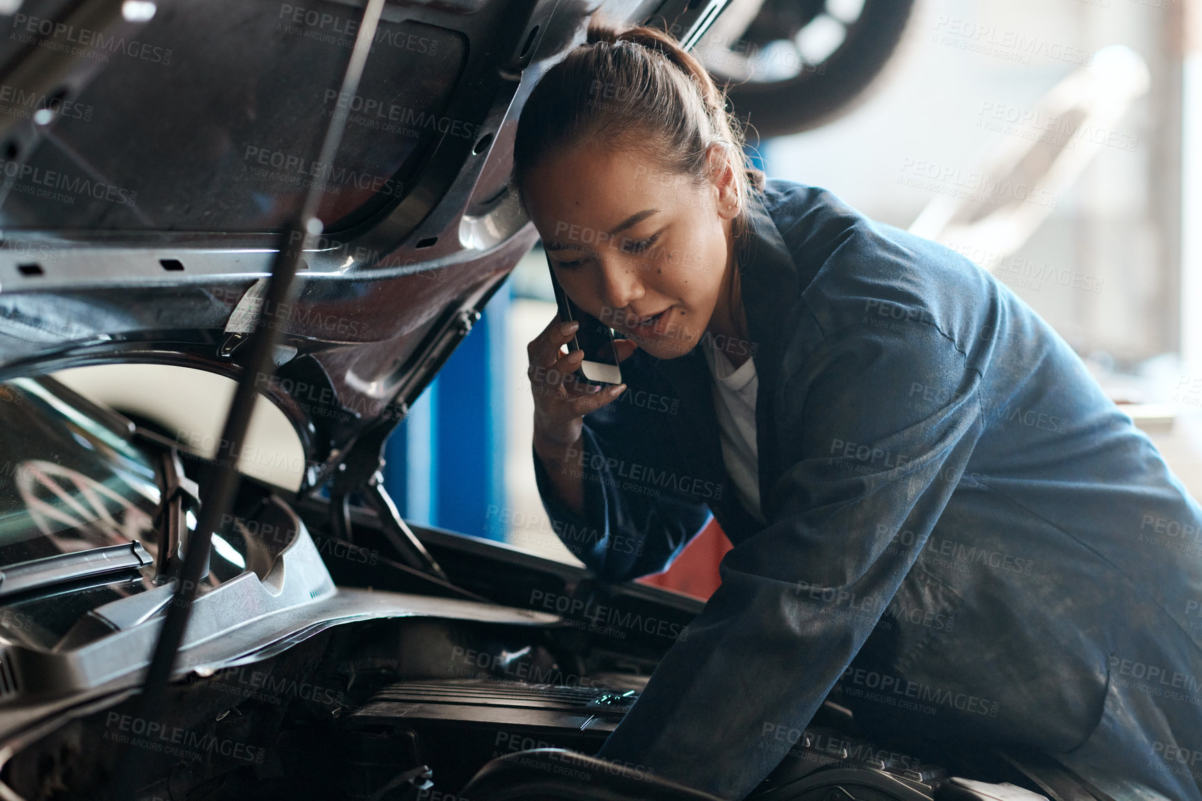 Buy stock photo Car, mechanic and phone call with woman in workshop for maintenance, repair or service of engine. Auto, expert and inspection with asian vehicle engineer or technician in garage for communication