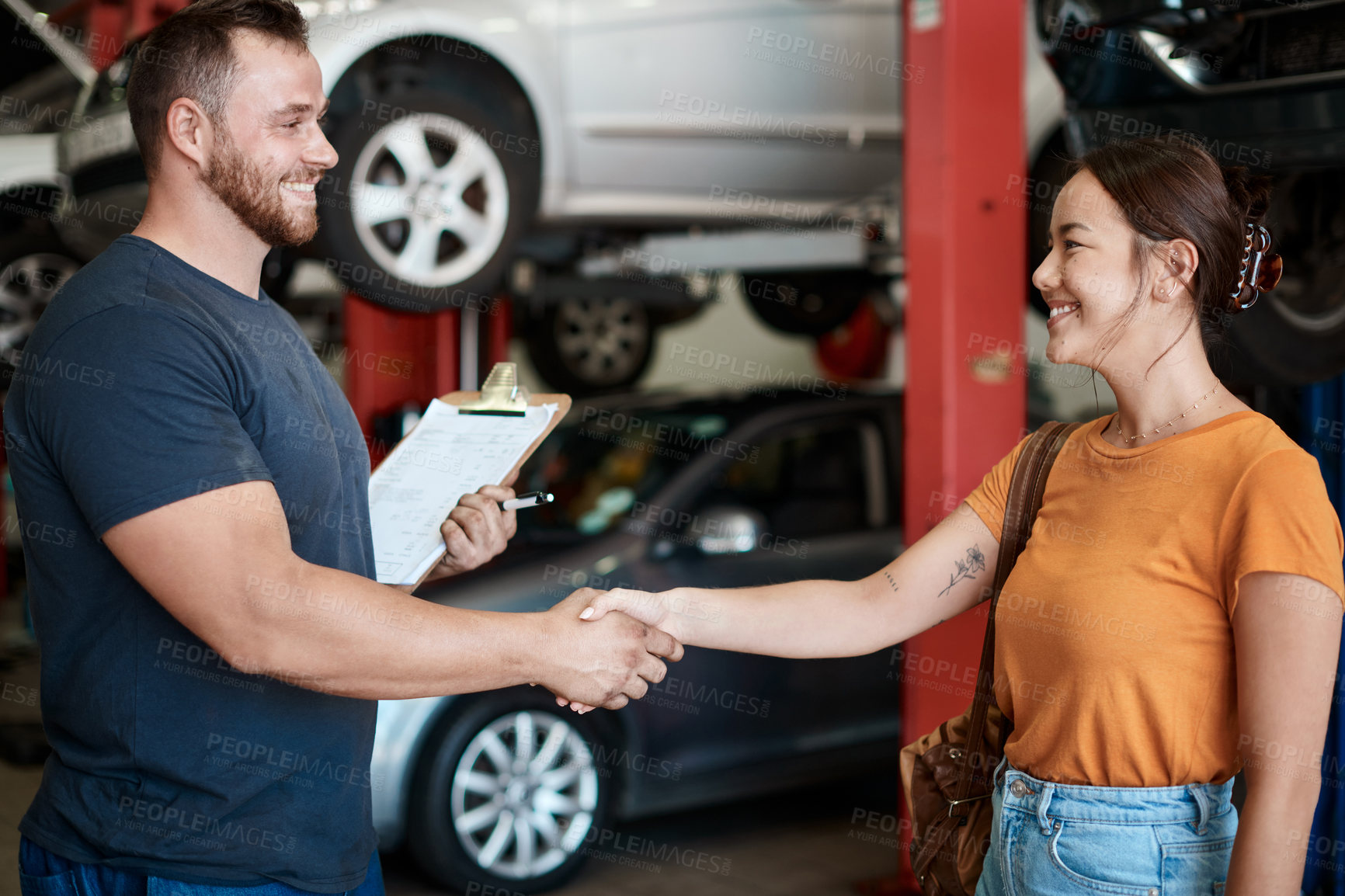 Buy stock photo Shaking hands, smile and woman with mechanic in workshop for deal on vehicle repair or maintenance. Clipboard, welcome and Asian person with industrial worker for handshake in garage for car service.