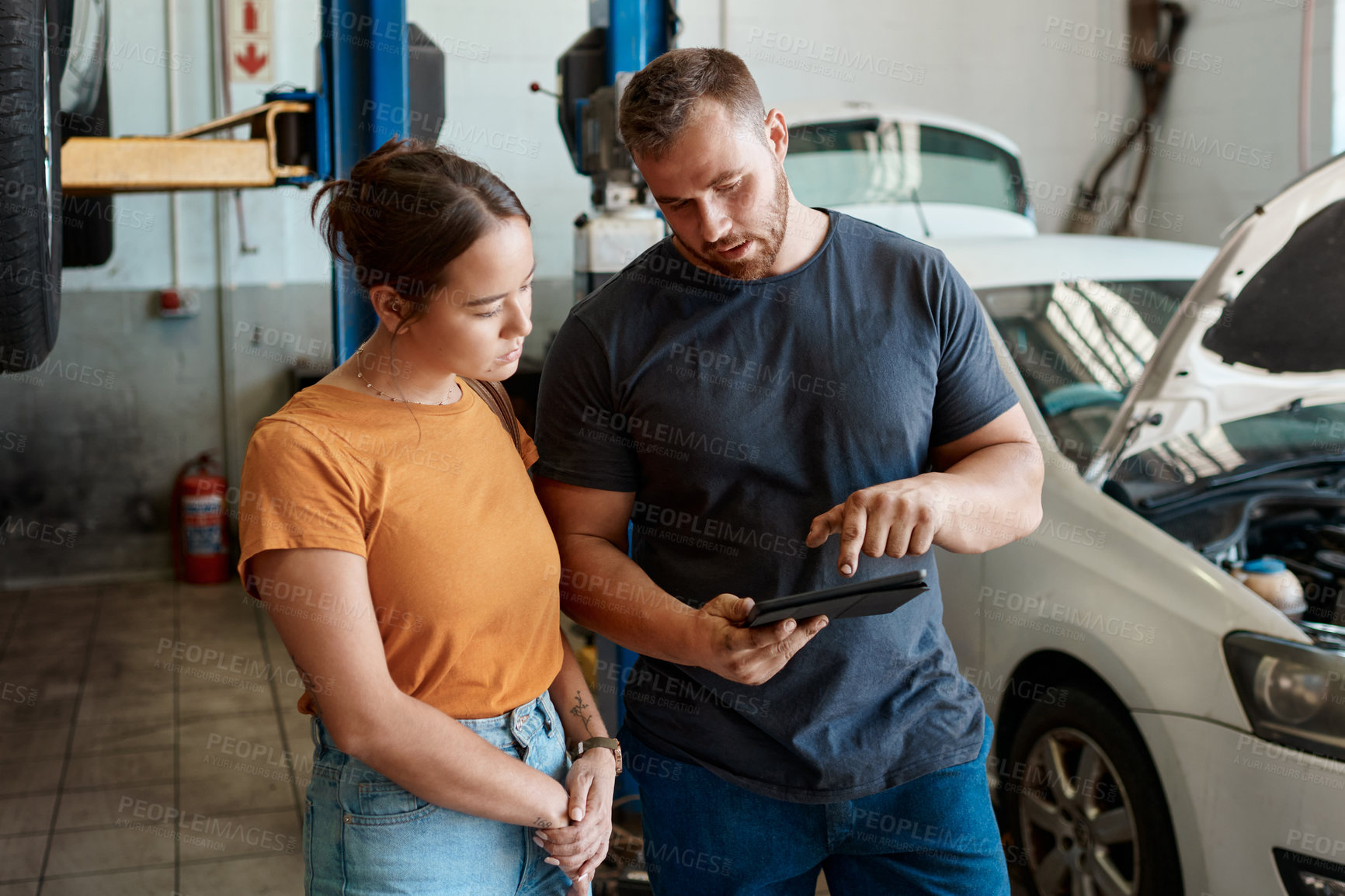 Buy stock photo Customer, diagnostic and tablet with mechanic in garage for inspection, maintenance or vehicle service. Woman, quotation and car as auto repair in workshop for engineering, test and motor performance