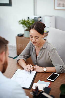 Buy stock photo Shot of a businesswoman reading through a contract with a customer