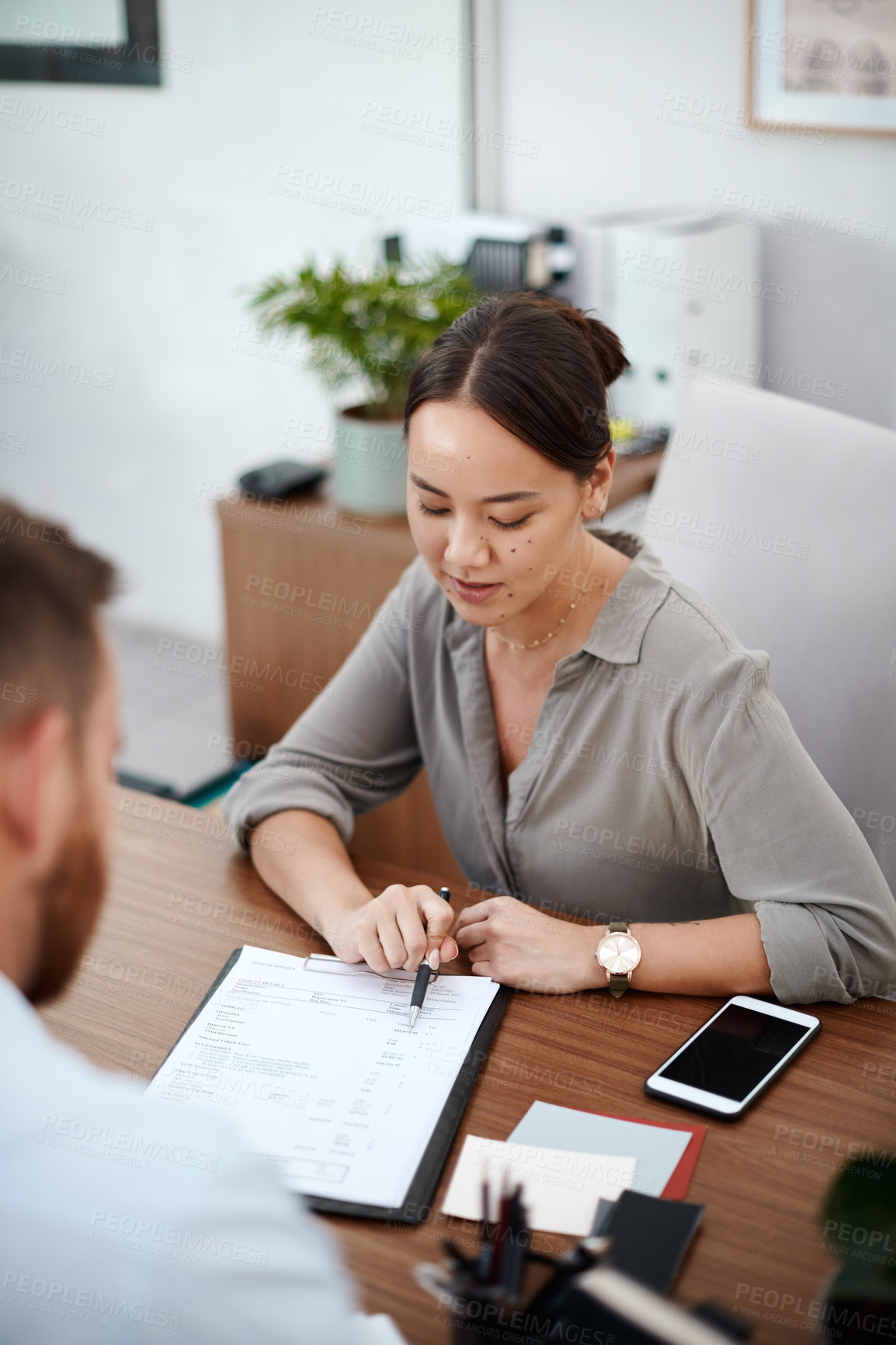 Buy stock photo Shot of a businesswoman reading through a contract with a customer