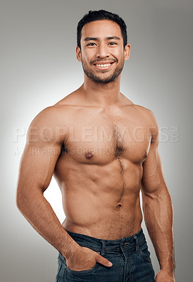 Buy stock photo Shot of a handsome young man standing alone and posing shirtless in the studio