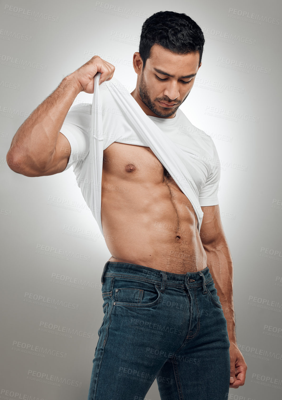 Buy stock photo Man, t shirt and remove in studio for fitness, wellness and strong abs muscle on gray background. Male person, clothes and take off for health, bodybuilder and proud of body or workout results