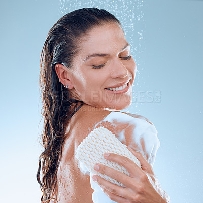 Buy stock photo Studio shot of a young woman taking a shower against a blue background