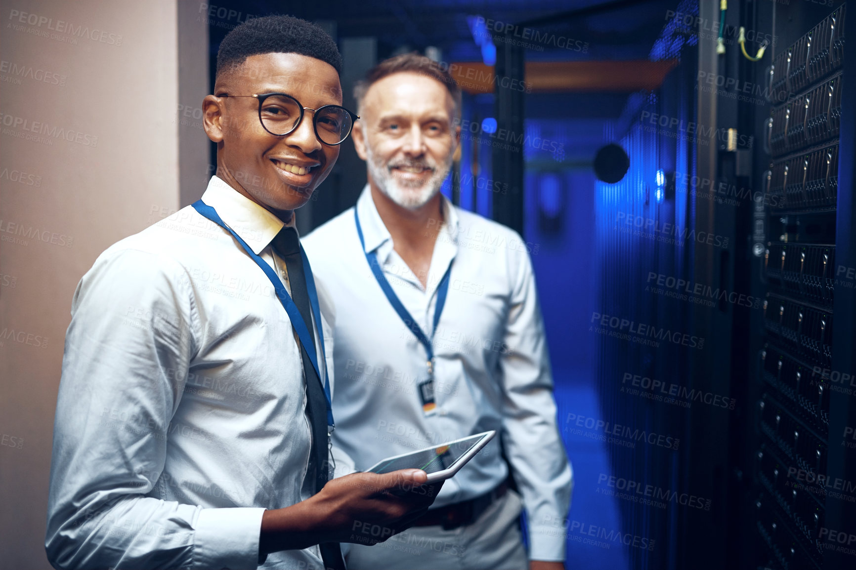 Buy stock photo Portrait of two technicians using a digital tablet while working in a server room