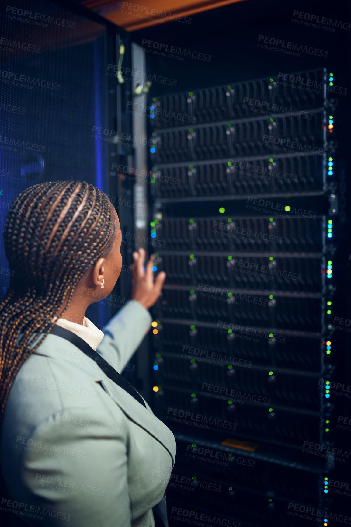 Buy stock photo Rearview shot of a young woman working in a server room