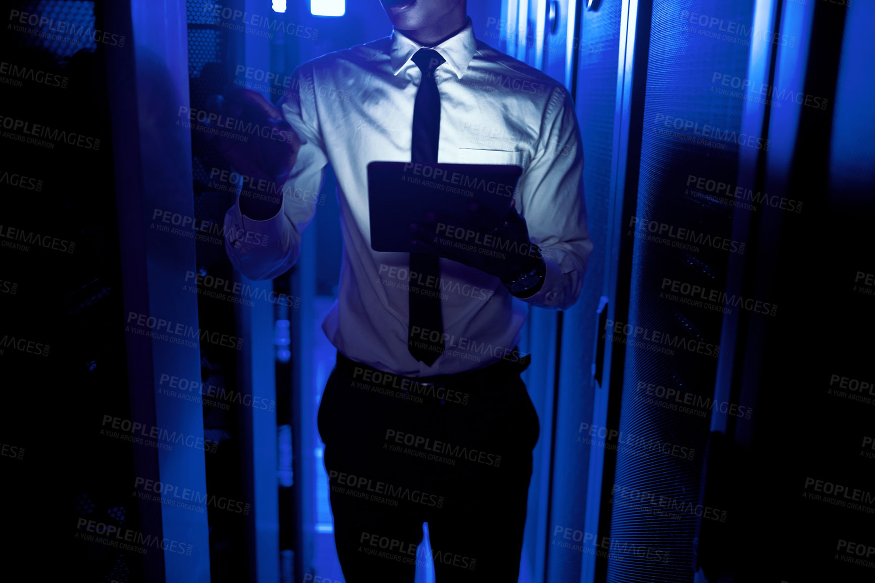 Buy stock photo Closeup shot of an unrecognisable man using a digital tablet while working in a server room