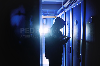 Buy stock photo Shot of a hacker using a digital tablet in a server room