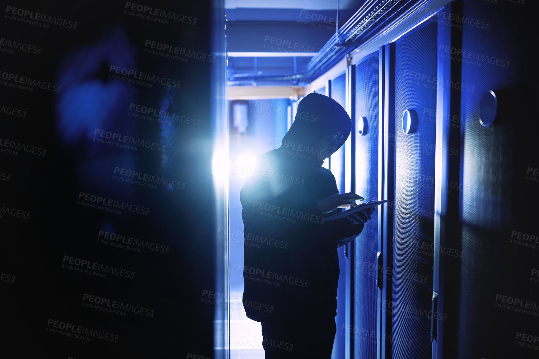 Buy stock photo Shot of a hacker using a digital tablet in a server room