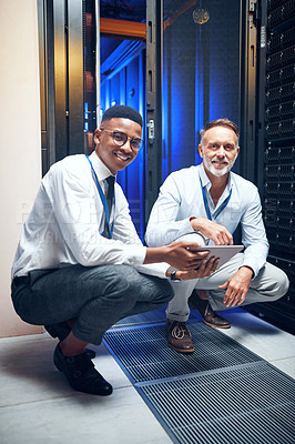Buy stock photo Portrait of two technicians using a digital tablet while working in a server room