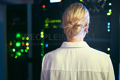 Buy stock photo Shot of an unrecognizable IT specialist standing alone in the server room