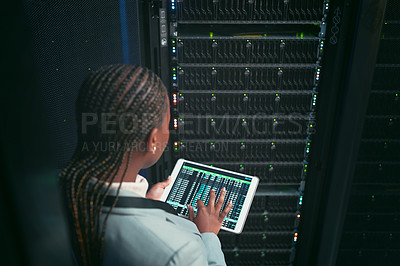 Buy stock photo Shot of an unrecognizable IT specialist standing alone in the sever room and using a digital tablet