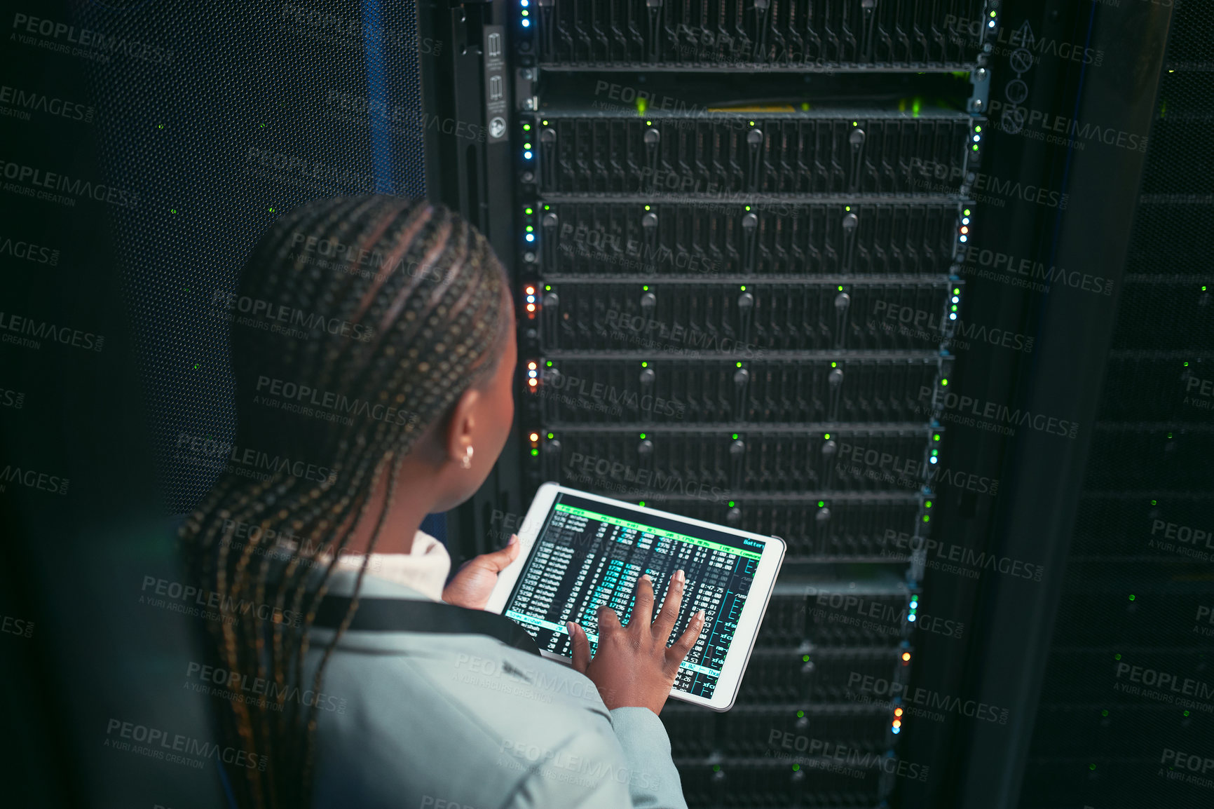 Buy stock photo Shot of an unrecognizable IT specialist standing alone in the sever room and using a digital tablet